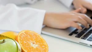 frutas e computador representando nutricionista digitando