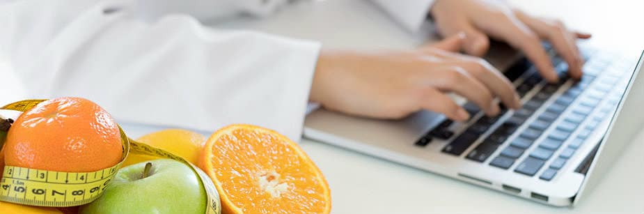 frutas e computador representando nutricionista digitando