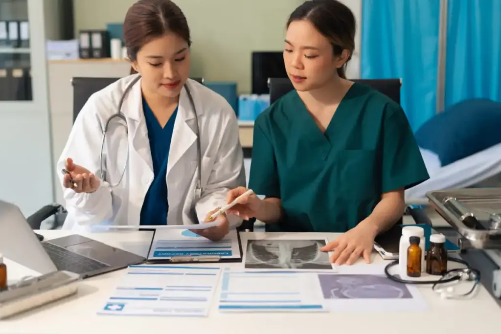 Duas médicas analisando fichas e exames para definir diagnóstico