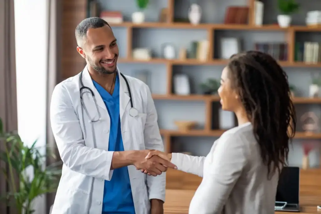 Médico acolhendo paciente com um aperto de mão