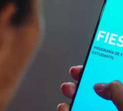 moça segurando celular com app do fies