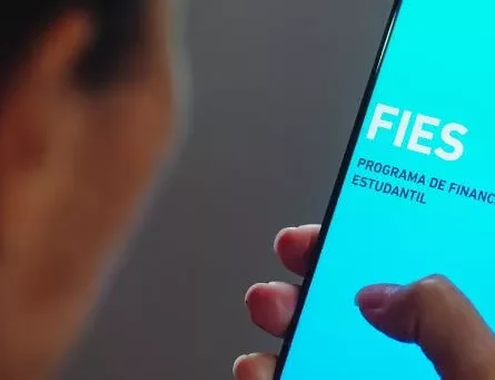 moça segurando celular com app do fies