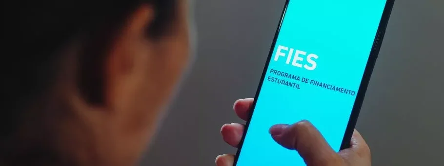 moça segurando celular com app do fies