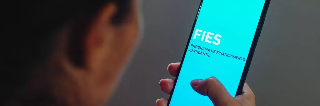 moça segurando celular com app do fies